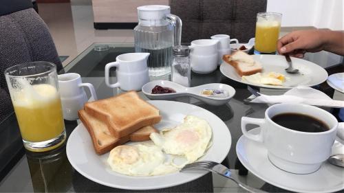 a table with two plates of eggs and toast and coffee at Siball Hotel in Abancay