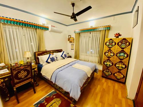 um quarto com uma cama e uma ventoinha de tecto em Experience Tibetan rooms em Pokhara