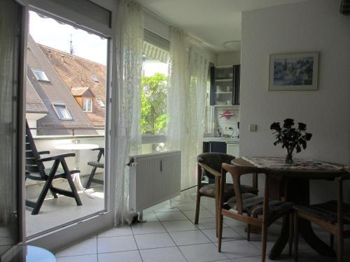 een woonkamer met een tafel en uitzicht op een keuken bij FeWo - Mitten In Freiburg in Freiburg im Breisgau