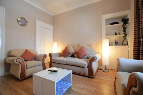 a living room with two chairs and a couch and a table at Keek Oot at 73 in Gourock