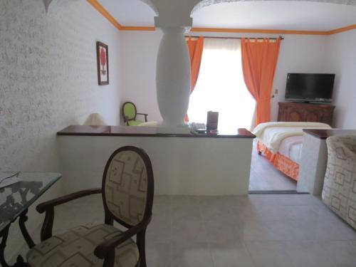 a bedroom with a bed and a table and a chair at Gran Hotel Hacienda De La Noria in Aguascalientes