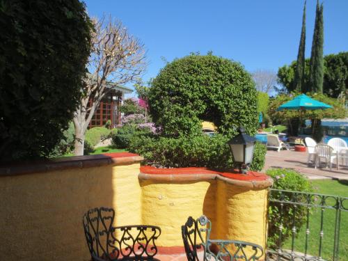 a couple of chairs sitting next to a wall at Gran Hotel Hacienda De La Noria in Aguascalientes