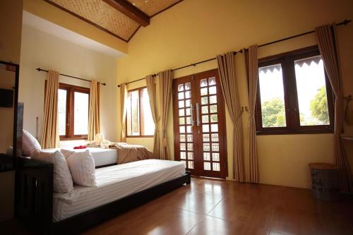 a living room with a couch and some windows at Grya Pyramyt in Banyuwangi