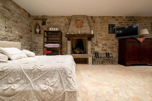 a bedroom with a bed and a stone wall at Mamihouse in Gubbio