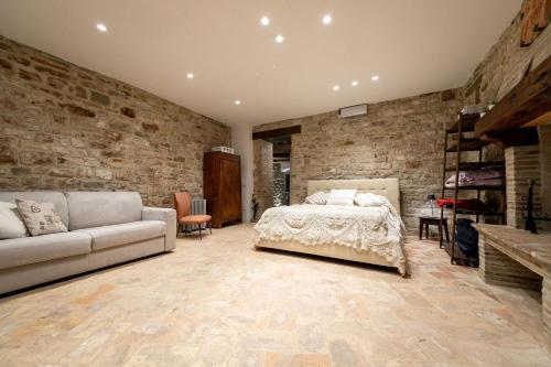 a bedroom with a bed and a brick wall at Mamihouse in Gubbio
