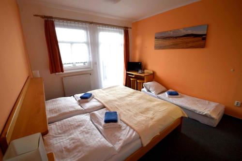 1 dormitorio con 2 camas y ventana en Hotel Emeran en Litvínov
