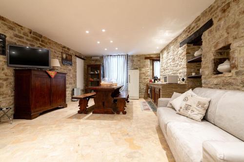a living room with a couch and a flat screen tv at Mamihouse in Gubbio