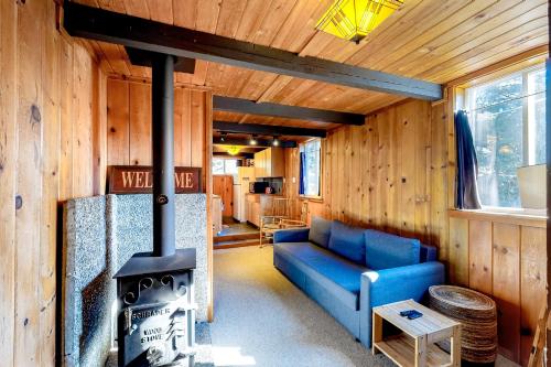 a living room with a blue couch and a stove at Sno-Bird #11 in Government Camp