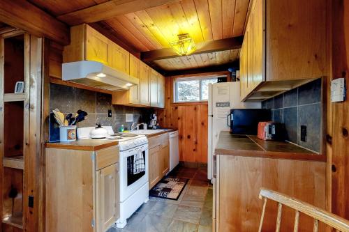 a kitchen with wooden cabinets and a white stove top oven at Sno-Bird #11 in Government Camp