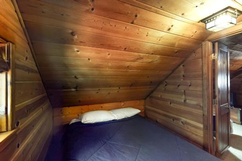 a small cabin with a bed in a wooden room at Sno-Bird #11 in Government Camp