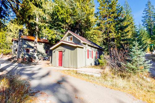 a small house with a red door next to a road at Sno-Bird #11 in Government Camp