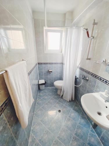 a bathroom with a toilet and a sink at Hotel Fancy in Sofia