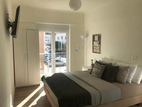 1 dormitorio con 1 cama grande y puerta corredera de cristal en Modern Double Room with Private Balcony en Montijo