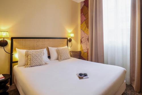 a bedroom with a large white bed with pillows at Ibis Styles Nantes Centre Place Graslin in Nantes