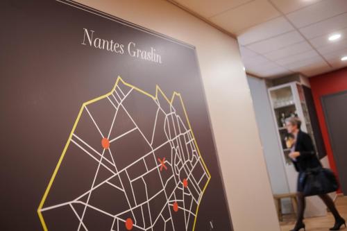 a woman walks past a sign in a store at Ibis Styles Nantes Centre Place Graslin in Nantes