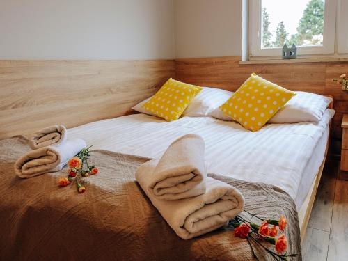 Una cama con toallas en un dormitorio en Willa Magnolia en Ciechocinek