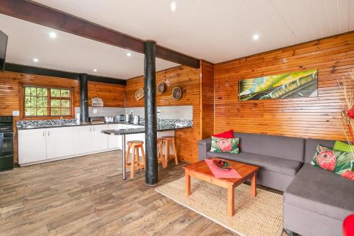a kitchen and living room with a couch and a table at Big Tree House Lodge in Knysna