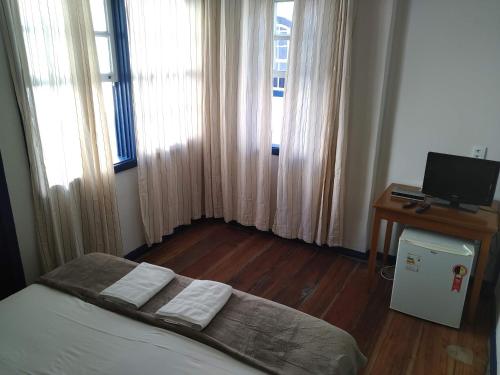 1 dormitorio con 1 cama y escritorio con ordenador en Hotel Barroco Mineiro, en Ouro Preto