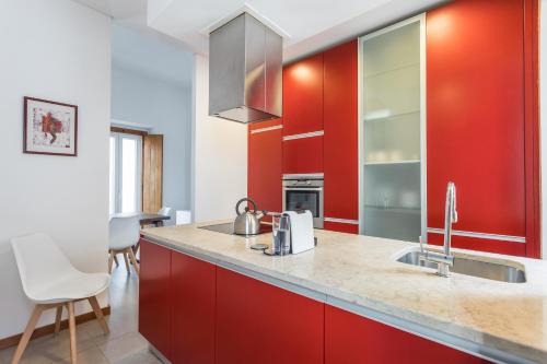 une cuisine avec des armoires rouges et un évier dans l'établissement Alfama Design Villa, à Lisbonne