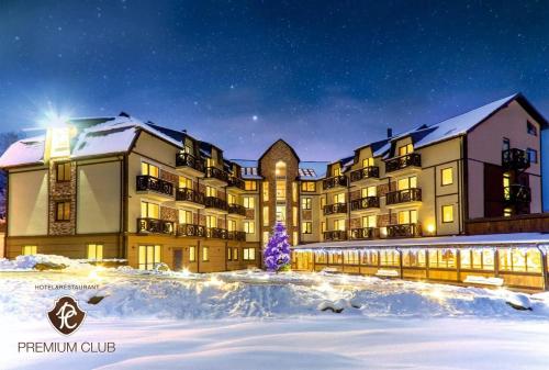 a resort in the snow with a christmas tree in front at Hotel&Restaurant Premium Club in Yaremche