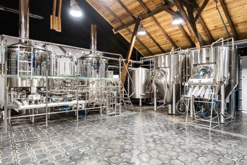 a brewery with a bunch of silver tanks at Hotel Spichrz in Borcz