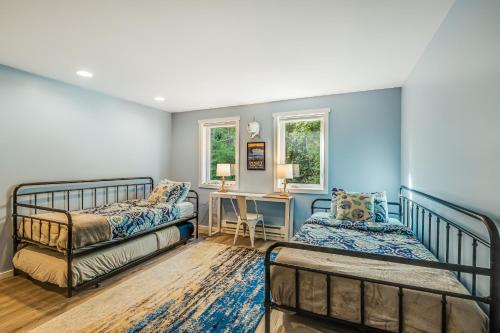 a bedroom with two beds and a desk at Heron House on the Cove in Coupeville