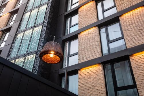 a light hanging from the side of a building at voco Strasbourg Centre - The Garden by IHG in Strasbourg