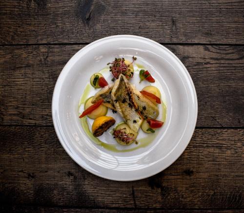 a plate of food with fish and vegetables on a table at Absolutum Wellness Hotel in Prague