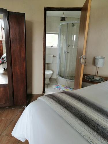 a bedroom with a bed and a bathroom with a shower at RonVu @ Bertram in East London
