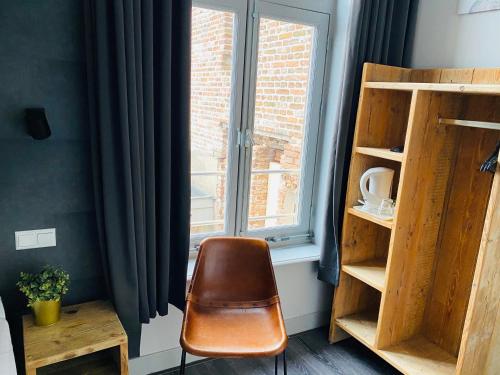 a brown chair sitting in front of a window at Hotel de Prince in Nijmegen
