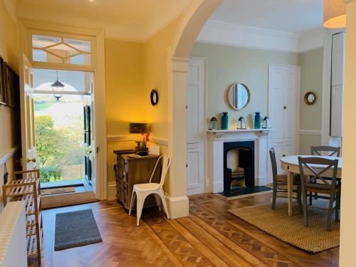 a living room with a table and a fireplace at The Westgate in Charmouth