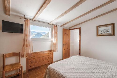 a bedroom with a bed and a window and a chair at Hotel Pini in Corniolo
