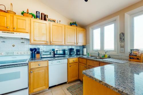 a kitchen with white appliances and wooden cabinets at Beaches n' Sunsets in Eastham