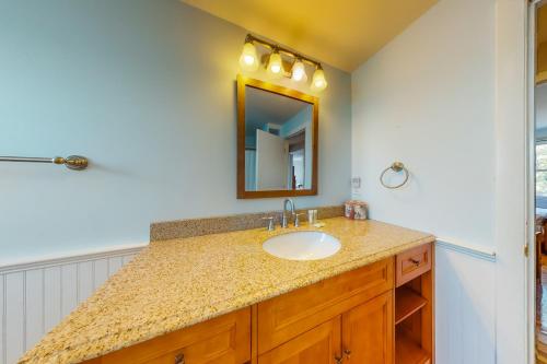 a bathroom with a sink and a mirror at Beaches n' Sunsets in Eastham