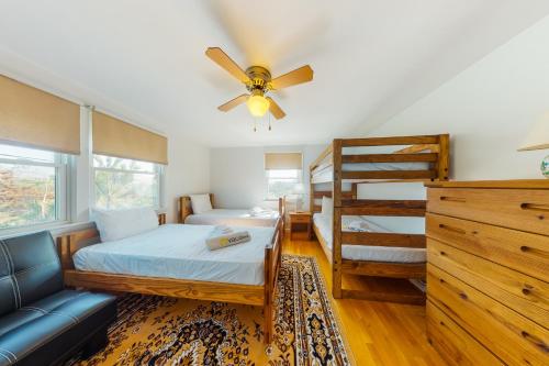 sypialnia z wentylatorem sufitowym i łóżkiem piętrowym w obiekcie Beaches n' Sunsets w mieście Eastham