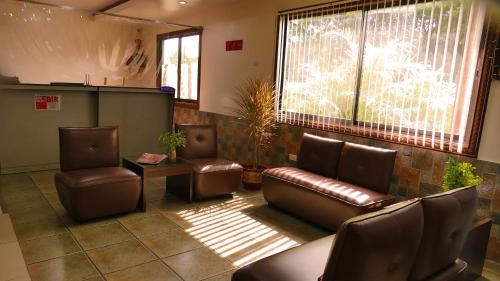 a waiting room with leather chairs and a couch at CounTess Pension House in Liloan