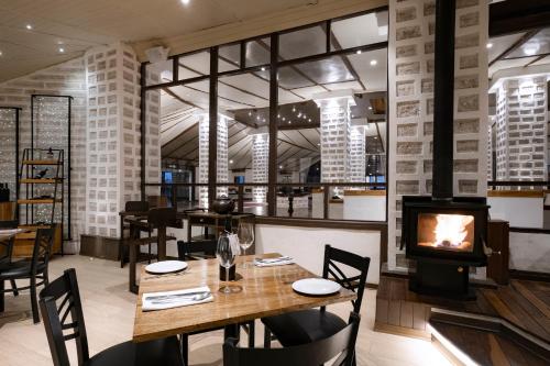 a restaurant with a wooden table and a fireplace at Hotel Palacio de Sal in Colchani