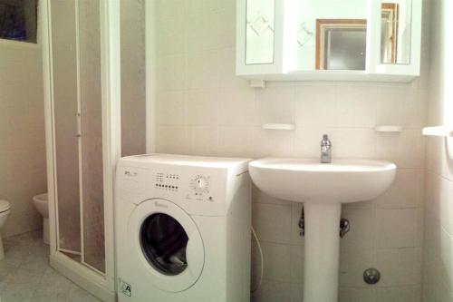 a bathroom with a washing machine and a sink at Nettuno 9C in Lido di Pomposa
