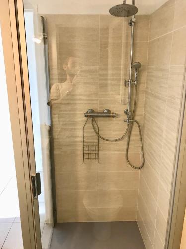 La salle de bains est pourvue d'une douche avec un homme. dans l'établissement Corse Villa Porticcio vue Mer, à Porticcio