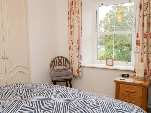 - une chambre avec un lit, une chaise et une fenêtre dans l'établissement Oak View, à Keswick