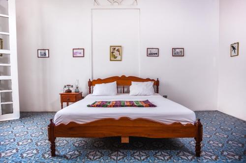 a bedroom with a large wooden bed with white sheets at Casa Morey in Iquitos