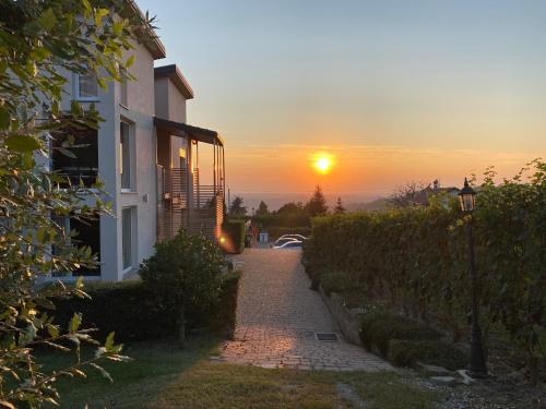 a sunset behind a house and a brick path at La Rosa Gialla Bio Apartments & rooms in Barolo