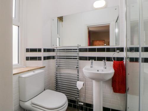 a white bathroom with a toilet and a sink at Holcombe House in Torquay