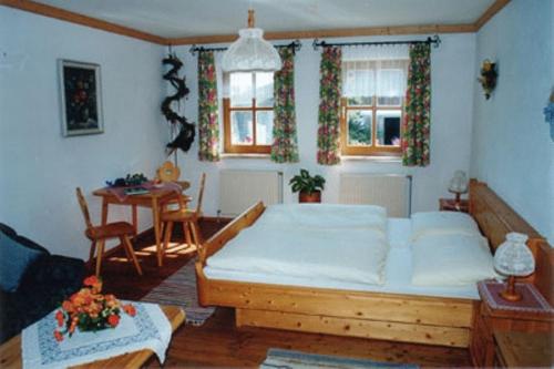 a bedroom with a large bed and a table at Reiterhof Stöglehner in Rainbach im Mühlkreis