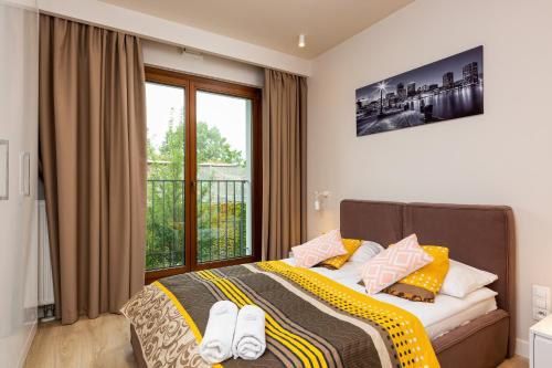 a bedroom with a bed and a large window at Apartments Warsaw Magazynowa by Renters in Warsaw