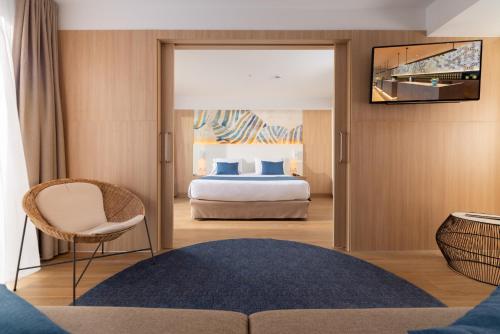 a hotel room with a bed and a television at L'Azure Hotel SPA 4Sup in Lloret de Mar