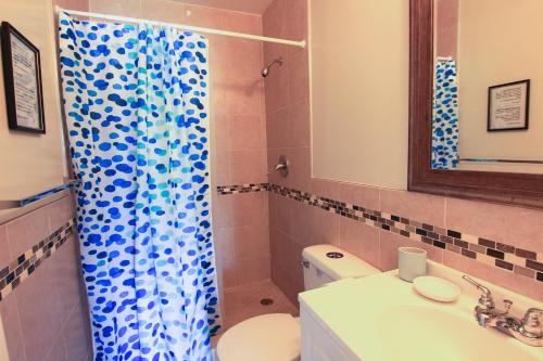 a bathroom with a blue shower curtain and a toilet at Sunny Isles Apartments by MiaRentals in Sunny Isles Beach