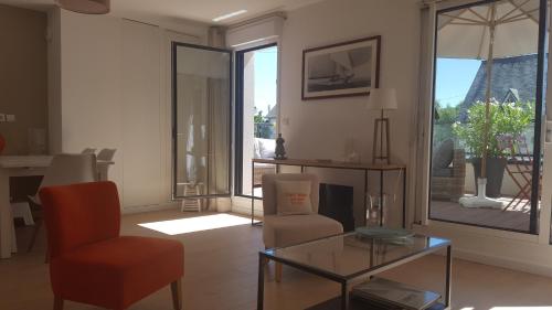 un salon avec une chaise et une table en verre dans l'établissement Les Cyprès - Appt avec terrasse proche plage, à Saint-Malo