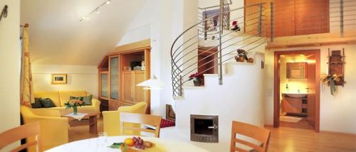 a living room with a table and chairs and a staircase at Ferienwohnung Anderl in Obertauern