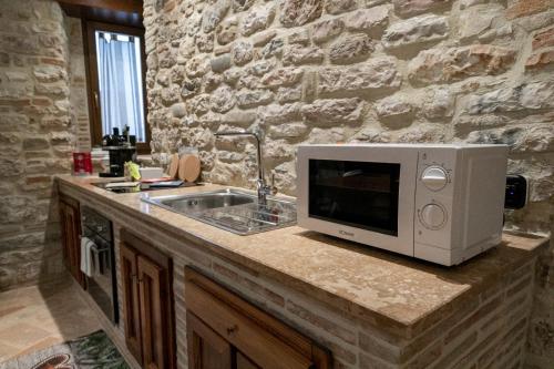 a kitchen counter with a microwave and a sink at Mamihouse in Gubbio